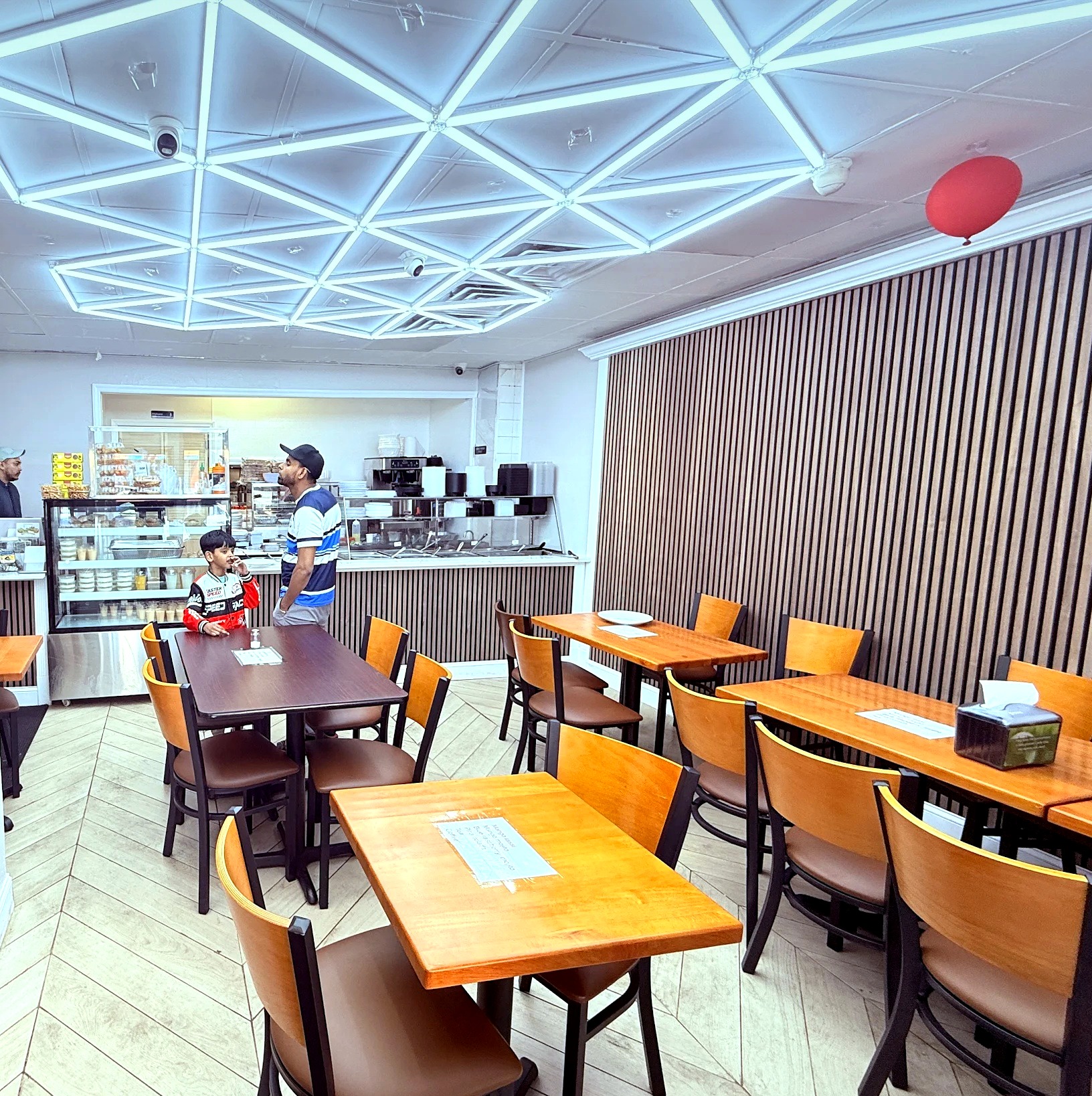 The dining room with wooden tables and an LED ceiling