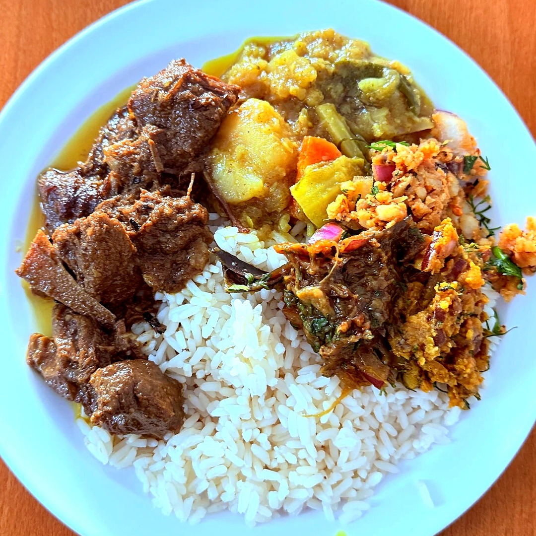 A plate of beef mandi with rice and curries